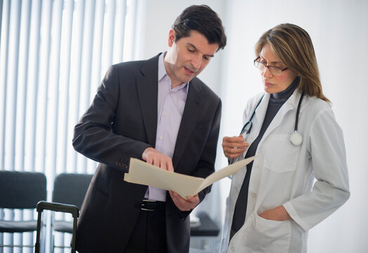 USA, New Jersey, Jersey City, Medical sales representative talking with female doctor in office