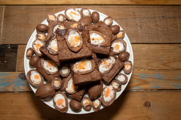 A plate of delicious chocolate cream easter egg brownies, chocolate easter eggs treats on a wooden kitchen table