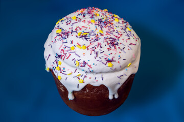 Easter holidays isolated sweet bread, paska decorated with sugar icing on blue background. Orthodox handmade kulich dessert with topping. Spring holidays food