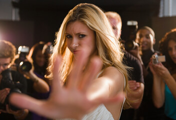 Celebrity blocking paparazzi at red carpet event