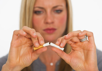 Young woman breaking cigarette