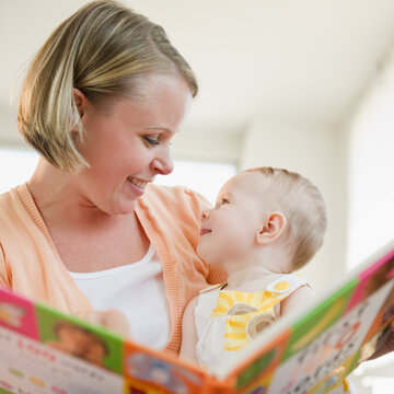 Mother reading book to her baby daughter
