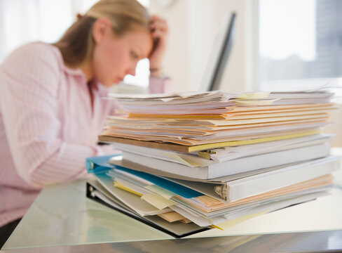 USA, New Jersey, Jersey City, Stressed young businesswoman doing paperwork