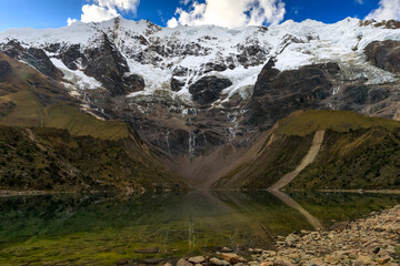 Fototapeta na wymiar Beautiful, calm and symmetric water reflection of the Salkantay mountain range on the cold waters of the Humantay lake in Peru