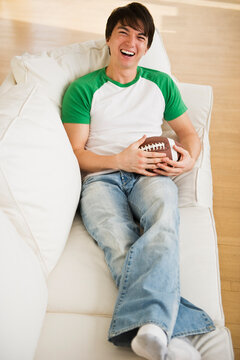 Male football fan relaxing on couch