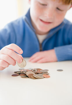 Portrait of boy (8-9) counting coins