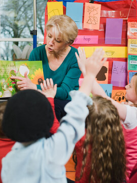 Elementary school teacher reading book to students