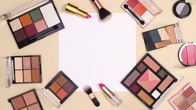Make up cosmetics products appear around paper card note on nude background. Beauty flay lay stop motion