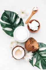 Fototapeta na wymiar Composition with coconut products, coco oil in jar and tropical leaves. Care products