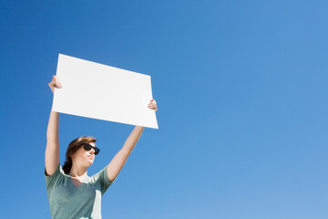 Young woman holding a blank placard