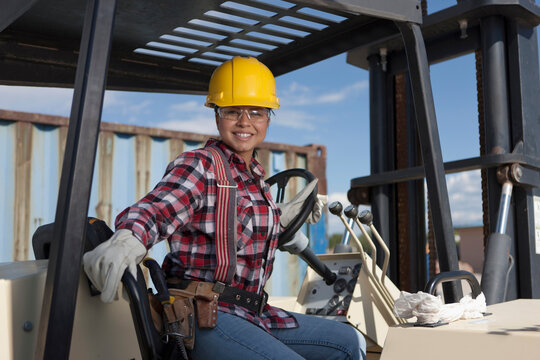 Portrait Of Female Construction Worker Driving Mechanical Digger