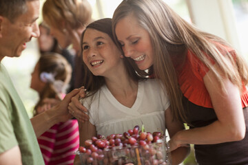 Girl (10 -11,) with family during celebration event
