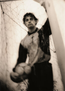 Soccer player standing behind net