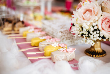 Cakesicles and a flower bouquet on the dessert table for the wedding party