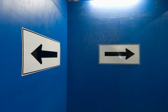 Arrow signs on blue wall