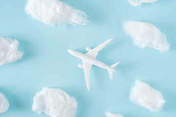 Fototapeta na wymiar White jet airplane flying between the fluffy clouds. Travel around the world creative concept
