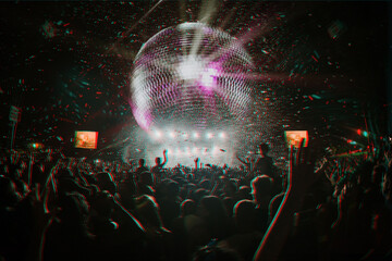 Crowd at a festival dancing with their hands up and a giant disco ball with glitch effect