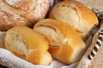 Closeup of basket with one Italian bread and three baguettes or french breads. 