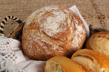 Closeup of basket with one Italian bread and three baguettes or french breads. 