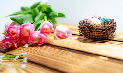 Spring Pink Tulips and Easter Egg Nest on Wood