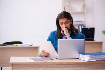 Young male employee working at workplace