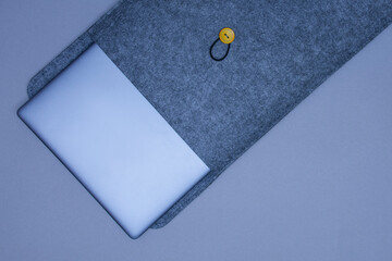 Closed silver laptop in a protective case on a gray background. Top view.