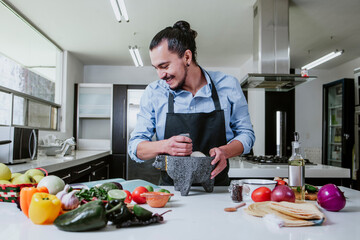 mexican man cooking at home preparing mexican sauce in kitchen at home in Mexico city