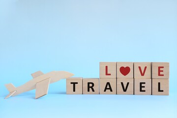 Wooden airplane model with blocks on sky blue background. Love travel and holiday vacation concept.	