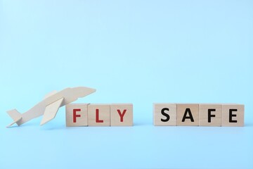 Wooden airplane model with blocks on sky blue background. Fly and travel safe concept.	