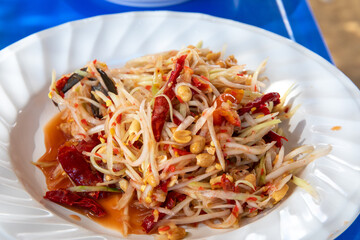Closeup to Famous Thai food, papaya salad or SOM TAM or Somtum. on the white plate or dish.