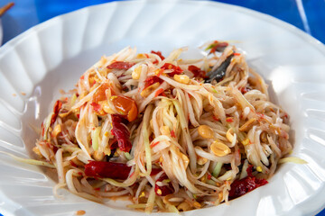 Closeup to Famous Thai food, papaya salad or SOM TAM or Somtum. on the white plate or dish.