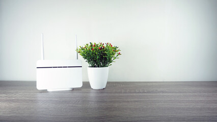 Wi-Fi modem with artificial flower sit on table in white background