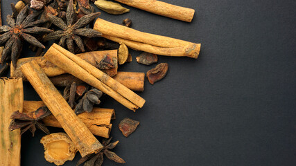 Various spices and herbs such as Star Anise, Cinnamon, Clove and Cardamom in black background.
