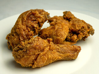 Fried chicken pieces on a bank plate, chicken breaded with spices.