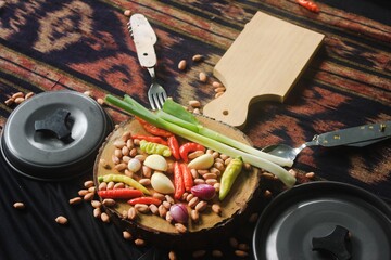pans, knives, cooking utensils and kitchen ingredients such as chilies, shallots, garlic, ready to cook.
