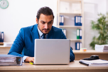 Young male employee and too many work in the office