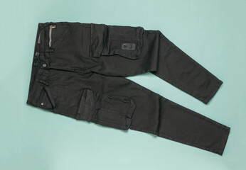 Cargo jeans in black on a light blue background.