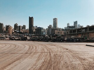 Fototapeta premium Road By Buildings And Stack Of Cars Destroyed By The Beirut Explosion Against Sky In City