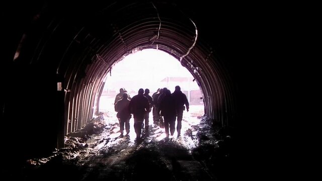 Group of Miners leaving the Mine at Sunset, View from Inside a Coal Mine in Patagonia, Argentina, South America.