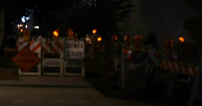 Caution signs and flashing lights in a construction zone fading from blurred to in focus