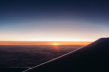 Airplane wing against the sunset sky