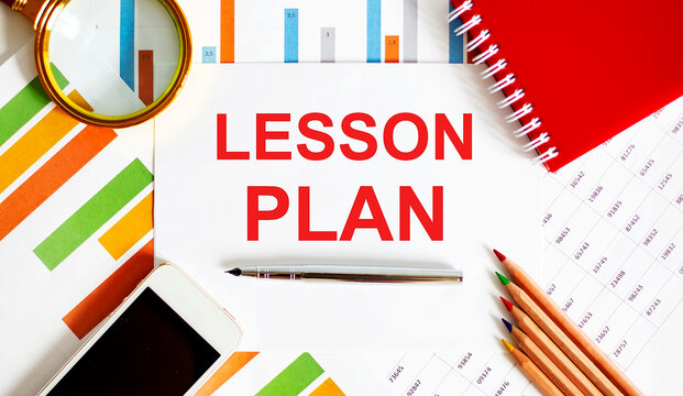 Text LESSON PLAN on the notepad with office tools, pen on financial report