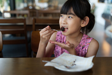 Asian child cute girl Eat Chocolate Cake
