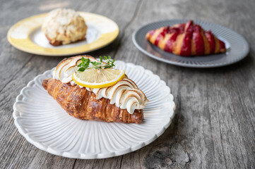 Top view of Lemon Croissant and others on wooden table. Croissant is a French buttery, flaky and crescent-shaped bread.