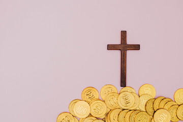 a cross is raised above a pile of coins