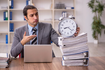 Young male employee in time management concept