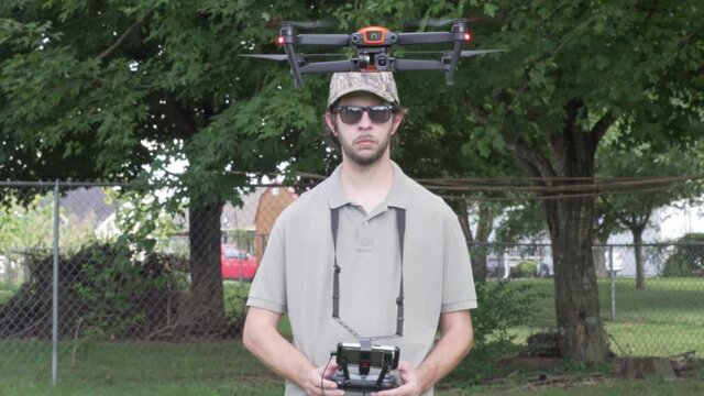 Professional Drone Pilot Flies drone UAS up and towards camera