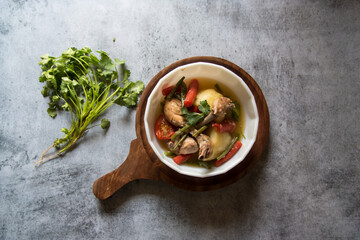 Healthy food chicken stew along with vegetables in a bowl on a wooden platter.