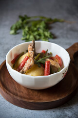 Close up of chicken stew along with vegetables in a bowl with use of selective focus.