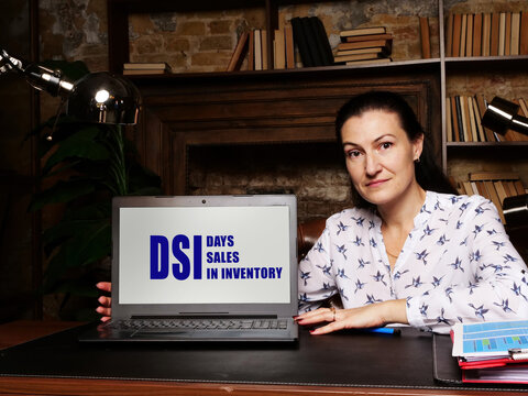 Business woman at work with financial reports  DSI DAYS SALES IN INVENTORY and a laptop
